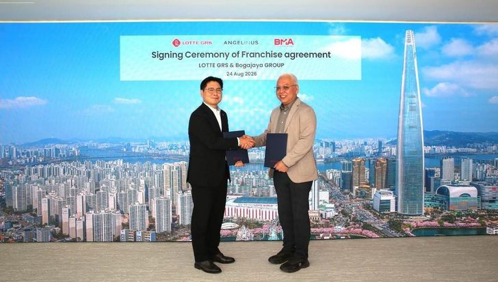 Lotte GRS CEO Lee Won-taek and Bogajaya Group CEO Budi Utomo shake hands at Lotte World Tower in Seoul after signing a master franchise agreement to develop 10 Angel-in-Us Coffee outlets in Indonesia over five years.